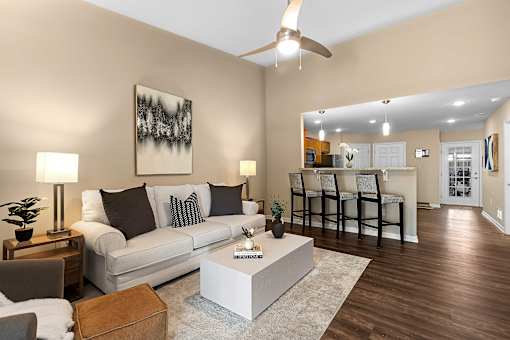 A living room with a white couch, a coffee table, and a painting on the wall.
