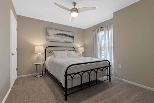 A bedroom with a bed, nightstand, and a ceiling fan.