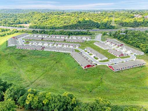 A large, well-maintained parking lot with multiple rows of cars and a few buildings.