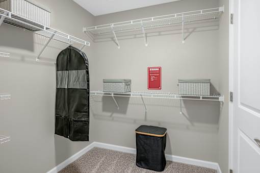 A small closet with a black bag on the floor.