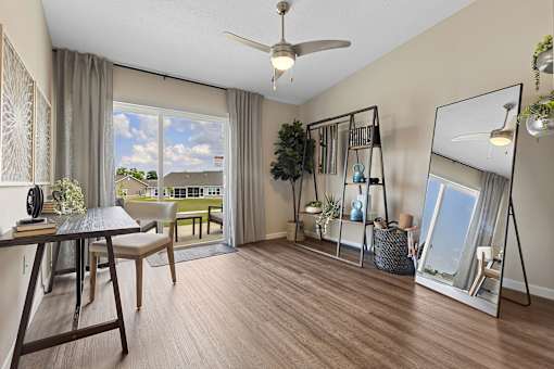 A well-lit room with a table, chairs, and a view of the outdoors through a sliding glass door.