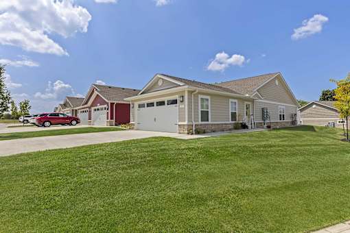 A house with a red car parked in front.