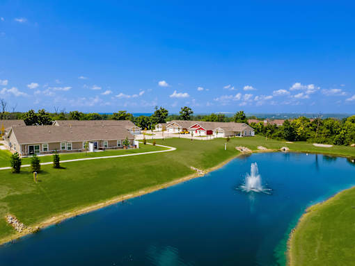 A beautiful aerial view of a house with a fountain in the front yard.