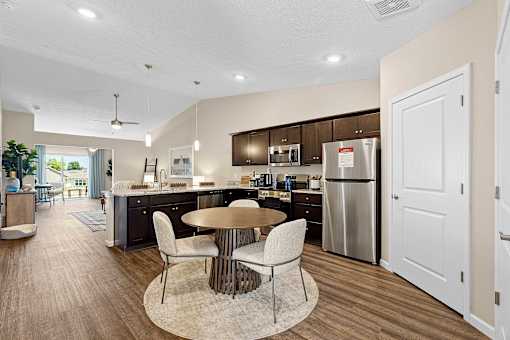 A modern kitchen with a dining table and chairs.