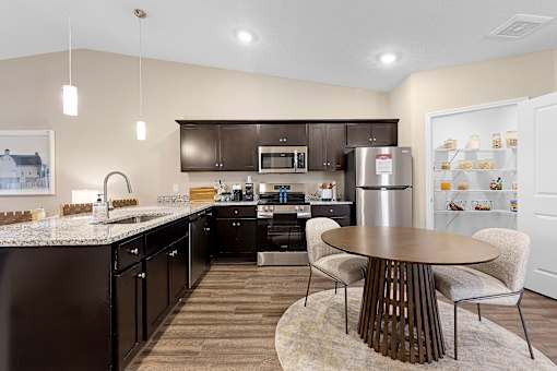 A modern kitchen with dark brown cabinets and a wooden table.