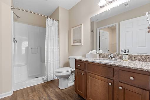 A bathroom with a toilet, sink, and shower.