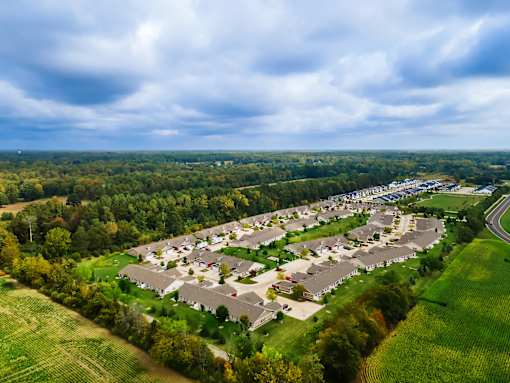 A bird's eye view of a residential area with houses surrounded by green fields.