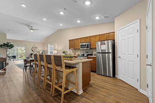 A kitchen with wooden chairs and a counter.