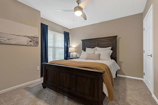 A bedroom with a large bed and a ceiling fan.