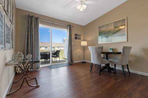 A room with a table and chairs and a fan.