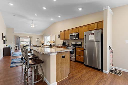 A kitchen with a refrigerator, microwave, and oven.
