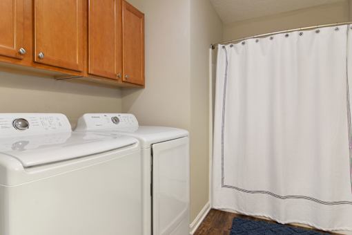 A white washing machine and dryer in a laundry room.