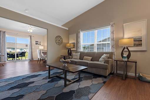 A living room with a couch, coffee table, and a large window.