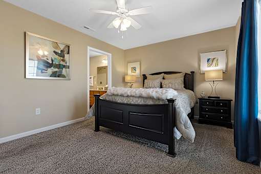 A bedroom with a bed, nightstand, and a ceiling fan.