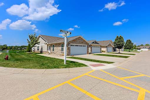 A street view of a residential area with houses and a street sign.
