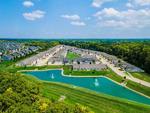 A large community with a pond and fountain in the middle.