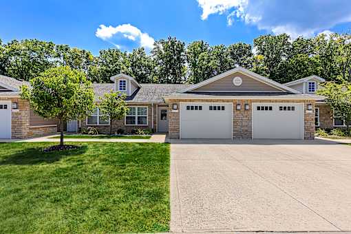 A large house with a driveway in front.