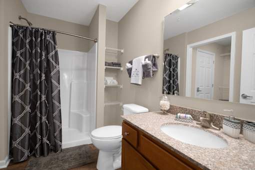 A bathroom with a toilet, sink, and shower curtain.