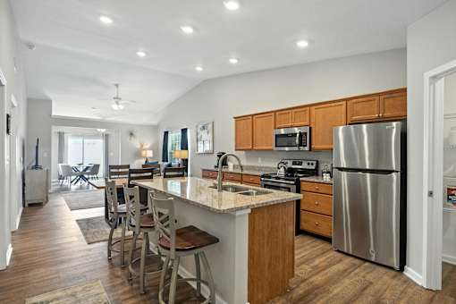 A kitchen with a refrigerator, microwave, and oven.