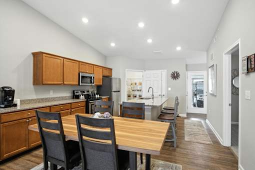 A kitchen with a table and chairs in the foreground.