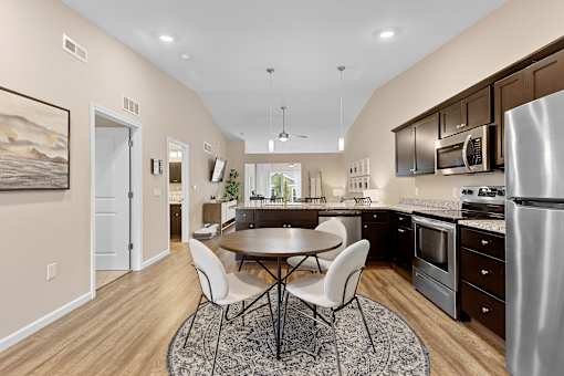 A modern kitchen with a dining table and chairs.