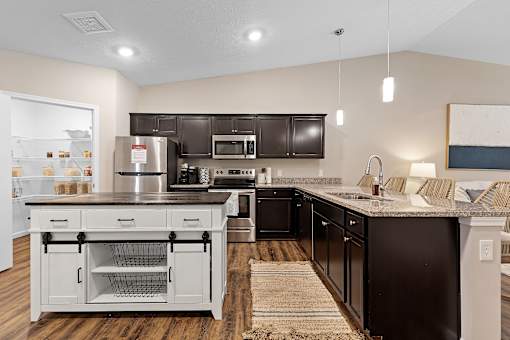 A modern kitchen with dark brown cabinets and a white island.