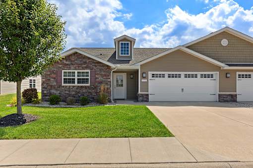 A house with a stone facade and a garage door.