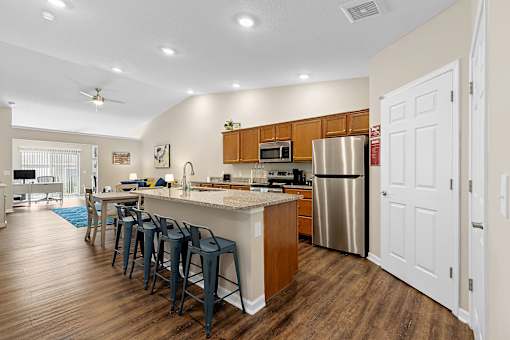 A kitchen with a bar area and a refrigerator.