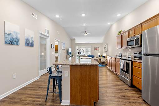 A kitchen with a wooden island and stainless steel appliances.