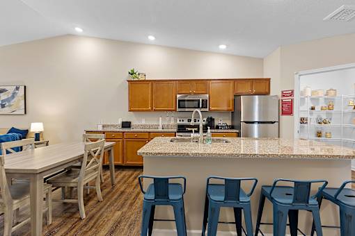 A kitchen with a table and chairs.