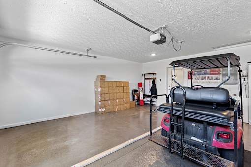 A room with a red vehicle and boxes in the background.