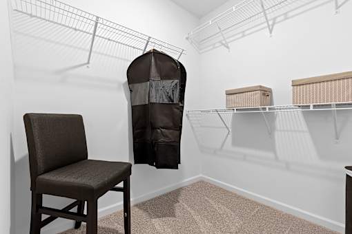 A chair sits in a room with a hanging chair and shelves.