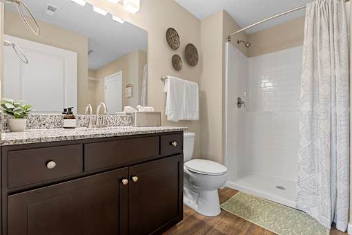 A bathroom with a toilet, sink, and shower.