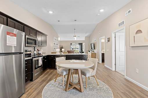 A kitchen with a table and chairs in the middle of the room.