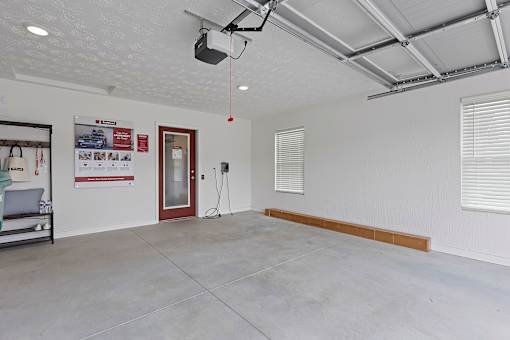 A room with a white wall and a red door.