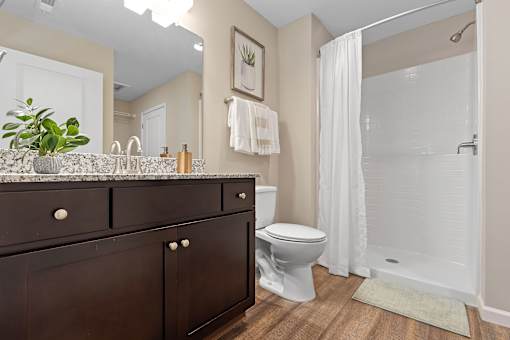 A bathroom with a toilet, sink, and shower.