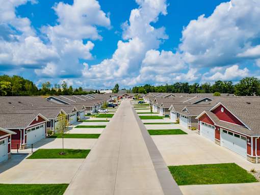 A row of houses with driveways leading to garages.