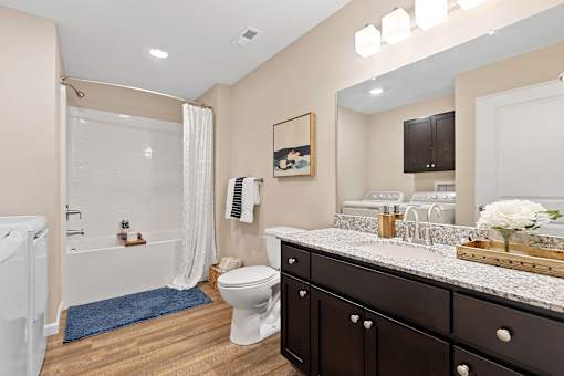 A bathroom with a white tub, a toilet, and a sink.