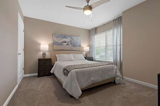 A bedroom with a large bed and a painting on the wall.