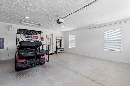 A room with a red and black vehicle and a white wall.