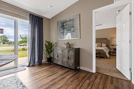A room with a large window and a wooden floor.