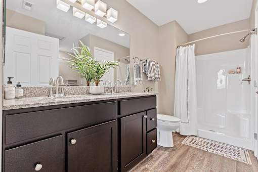 A bathroom with a white toilet and a white shower.