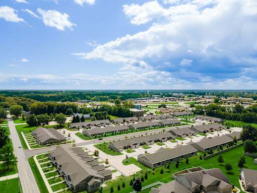 A bird's eye view of a residential area with houses and green lawns.