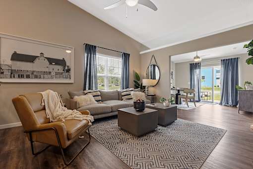 A living room with a brown leather chair and a grey sofa.