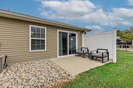 A house with a patio and a white fence.
