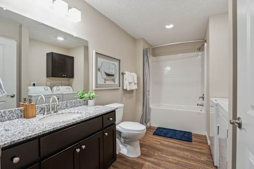 A bathroom with a white toilet, sink, and bathtub.