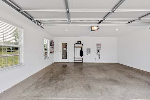 A large, empty room with a concrete floor and white walls.