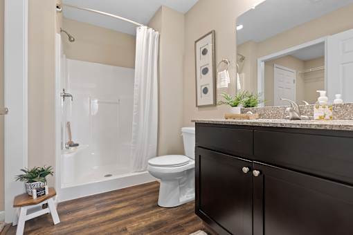A bathroom with a toilet, sink, and shower.