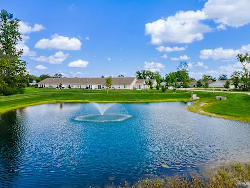 A fountain in the middle of a lake in a park.