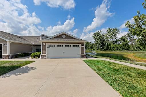 A house with a garage and a driveway in front of it.